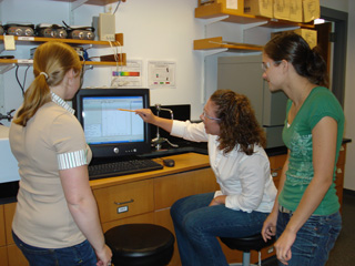 Amy Keirstead discusses UV-Vis data with undergraduate students Amber Zablowsky and Robyn Gaudet.